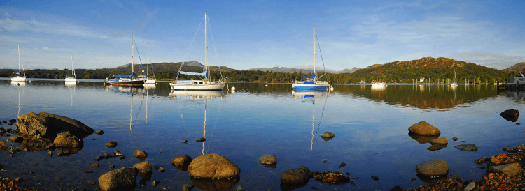 Boats sit on the placid waters of Lake Windermere at the end of the Dales Way.