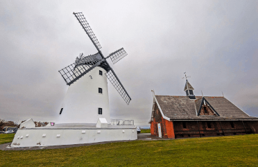 A whitewashed old-style windmill stands on the Lancashire Coast Path.